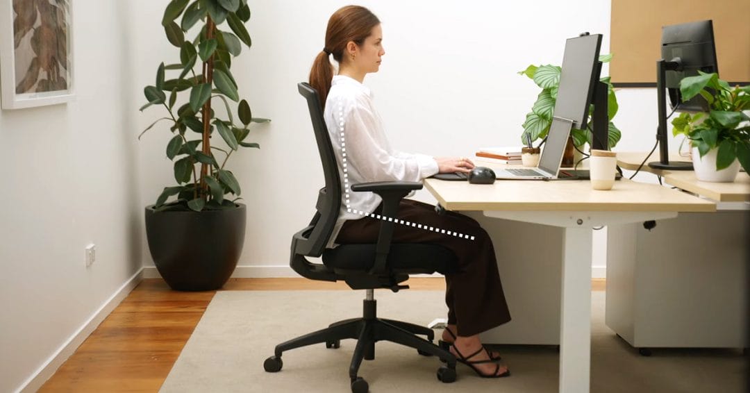 woman sitting in ergonomic position at desk