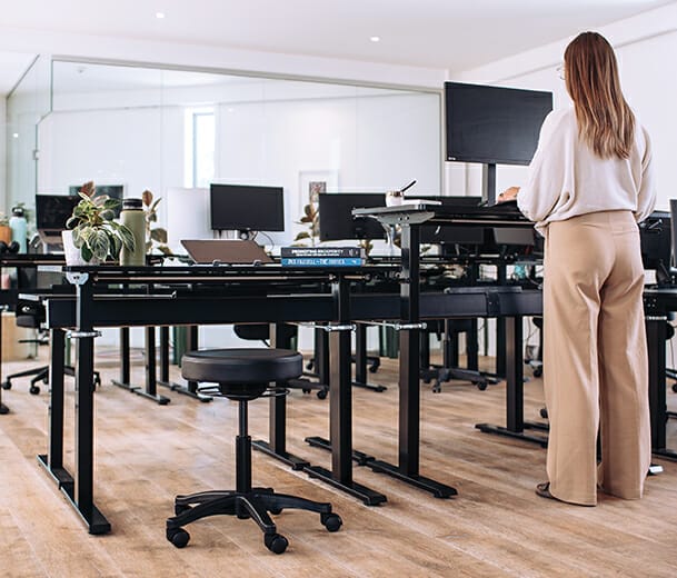 woman at standing desk with buro polo stool